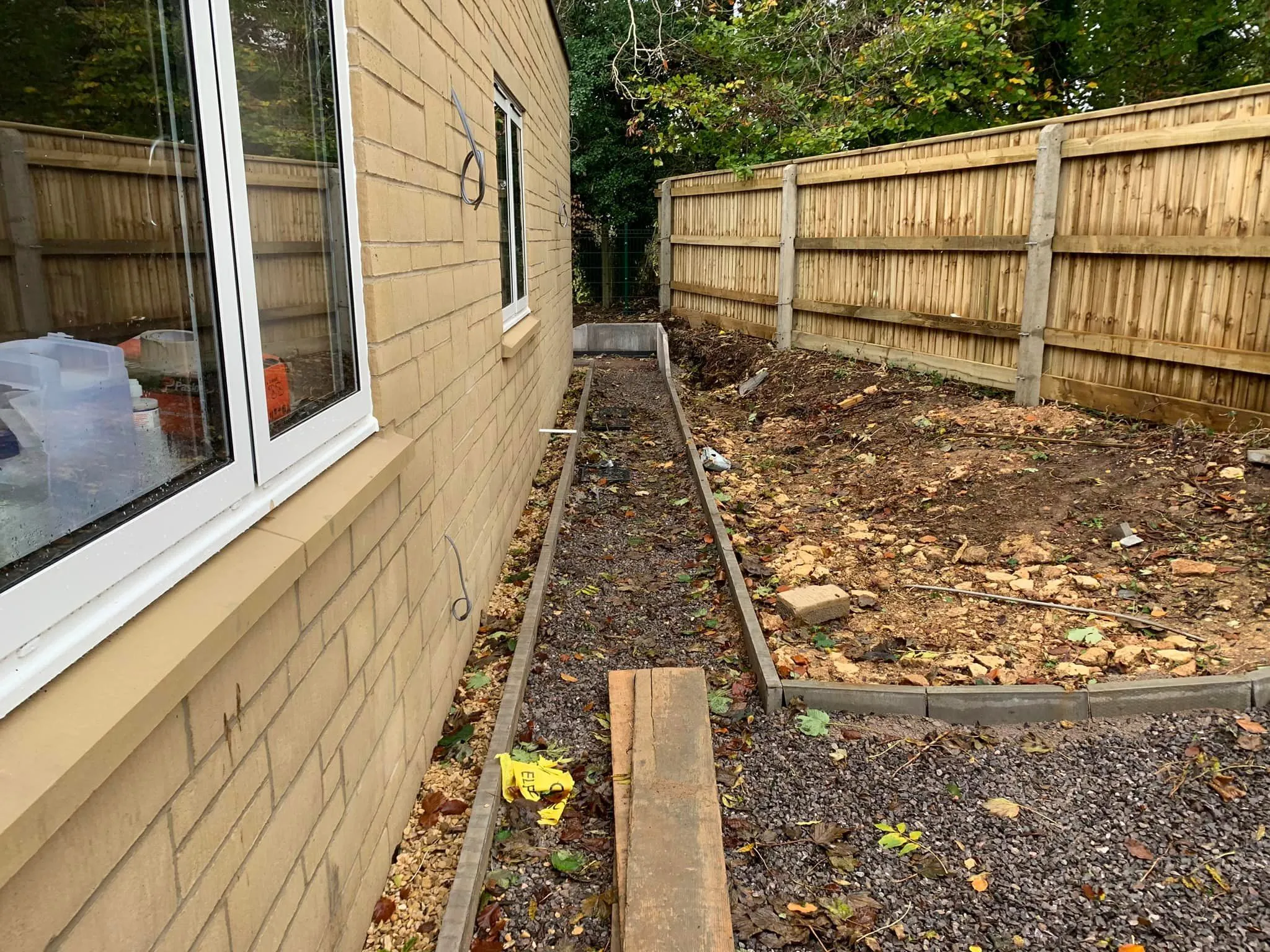 a back yard with a wooden fence and a flower bed
