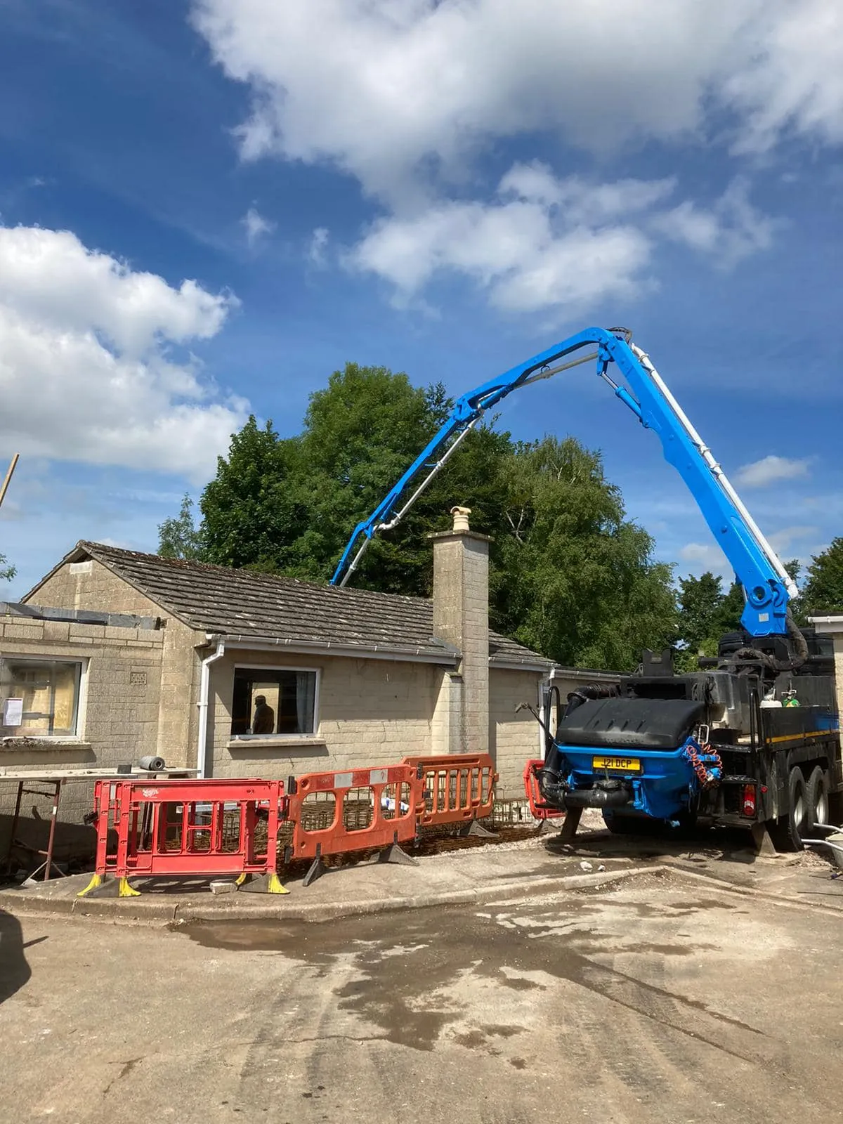 a blue crane is lifting a house into the air